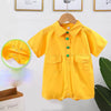 A bright yellow children's jumpsuit with green buttons, displayed on a hanger